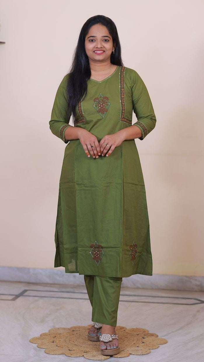 Woman wearing a SreeVastra olive green cotton 3-piece dress with intricate embroidery and three-quarter sleeves