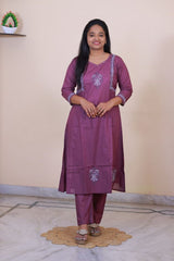 A woman wearing a SreeVastra purple cotton 3-piece dress with intricate white embroidery on the neckline and sleeves.