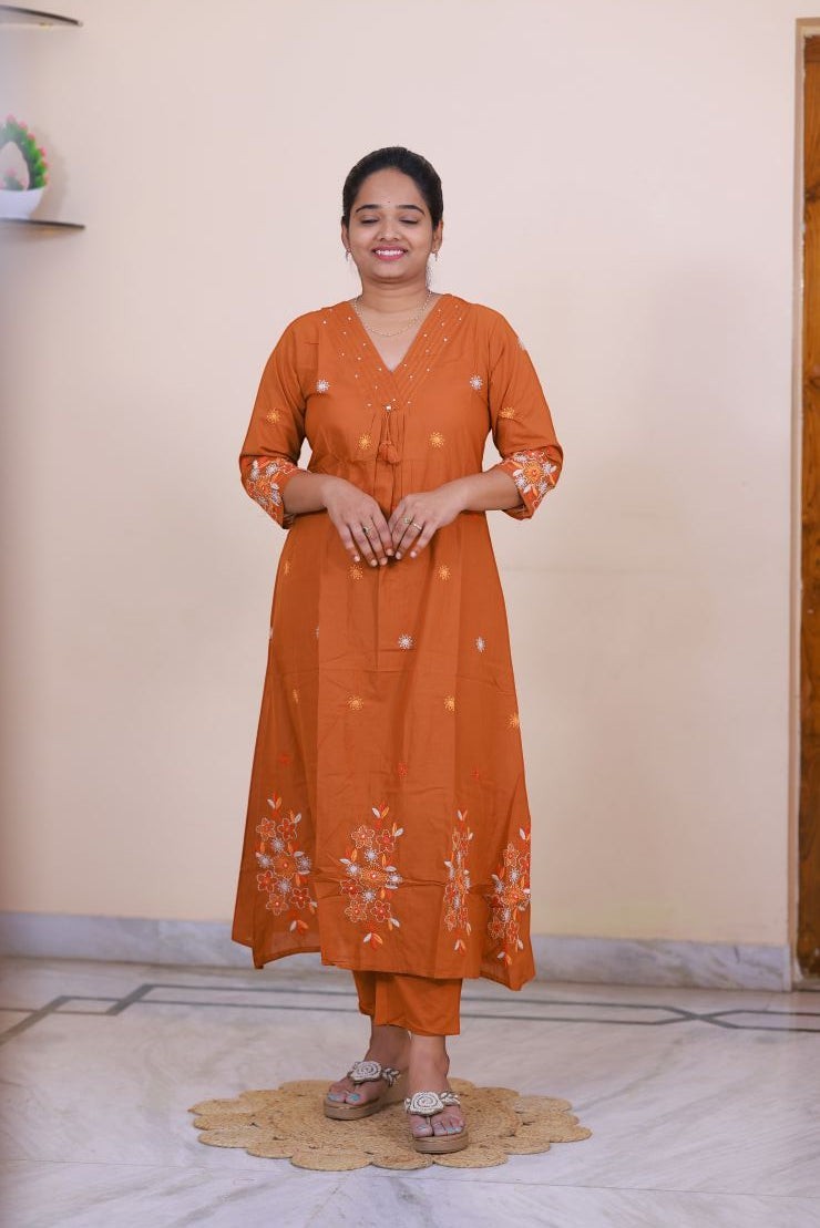 SreeVastra rust orange cotton 3 piece dress with white floral embroidery and v-neckline worn by a woman