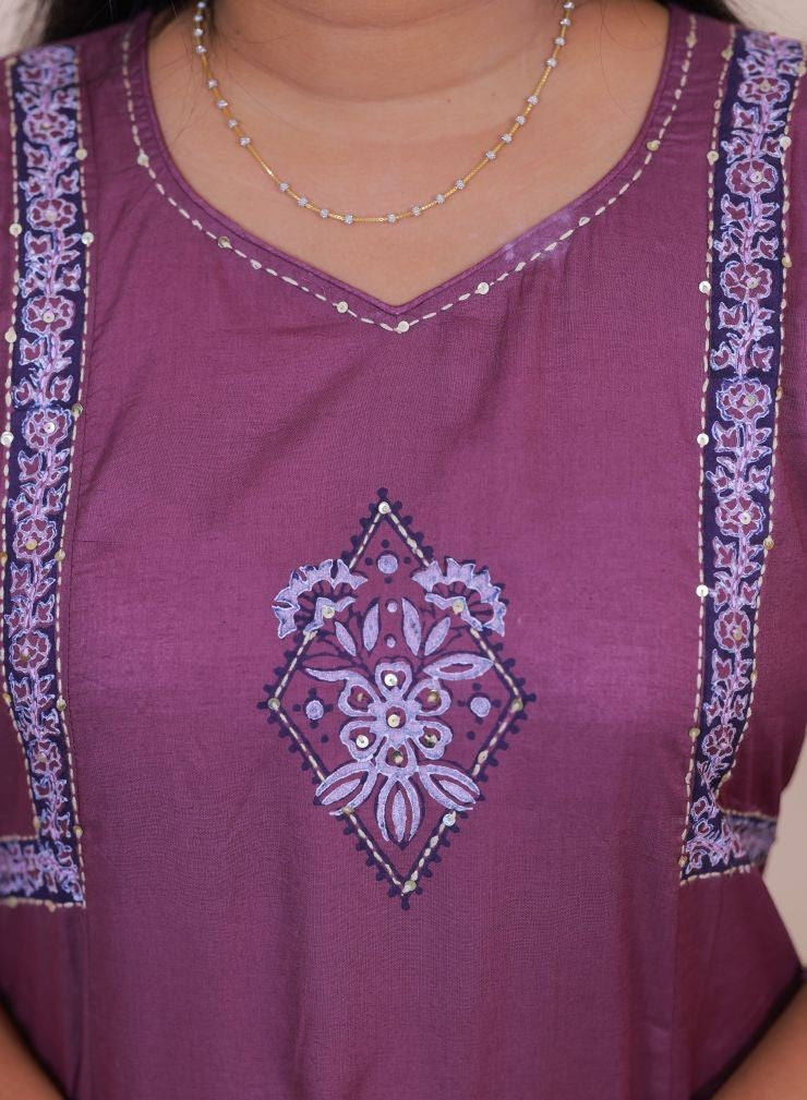 SreeVastra purple cotton dress featuring intricate floral embroidery, sequin detailing, and decorative border panels.