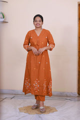 SreeVastra rust orange cotton 3 piece dress with white floral embroidery and v-neckline worn by a woman